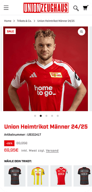 junger Mann im roten Union Berlin Heimtrikot 24/25 mit weißen Schulterstreifen vor rotem Hintergrund